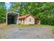 Exterior view of home featuring a red roof, a shed, and ample parking space at 154 Knucklesville Rd, Rydal, GA 30171