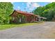 Exterior view of a rustic home with a red roof and ample parking space at 154 Knucklesville Rd, Rydal, GA 30171