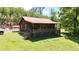 Charming cabin with a large covered porch, a metal roof, and an expansive lawn surrounded by trees at 154 Knucklesville Rd, Rydal, GA 30171