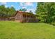 Charming log cabin with a metal roof and a spacious, covered front porch nestled in a green, wooded area at 154 Knucklesville Rd, Rydal, GA 30171