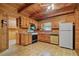 Traditional kitchen with wooden cabinets, updated appliances, and wood paneling at 154 Knucklesville Rd, Rydal, GA 30171