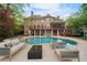 Luxury backyard featuring a pool, patio with fire pit, lounge seating, and lush landscaping at 1740 Doncaster Ne Dr, Atlanta, GA 30309