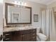 Well-lit bathroom with granite countertops, dark wood cabinetry, and a shower with tile surround at 1740 Doncaster Ne Dr, Atlanta, GA 30309