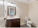 Bathroom with a wood vanity, white sink, toilet, and decorative mirror at 1740 Doncaster Ne Dr, Atlanta, GA 30309