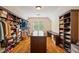 Spacious walk-in closet with custom shelving, a center island, and hardwood floors at 1740 Doncaster Ne Dr, Atlanta, GA 30309