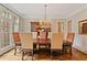 Formal dining room with large window, hardwood floors, elegant chandelier and seating for six at 1740 Doncaster Ne Dr, Atlanta, GA 30309