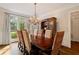 Formal dining room with large window, hardwood floors, elegant chandelier and seating for six at 1740 Doncaster Ne Dr, Atlanta, GA 30309