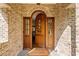 Grand wooden front door with sidelights, set in a brick archway, welcoming you into the home at 1740 Doncaster Ne Dr, Atlanta, GA 30309