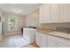 Bright laundry room with tiled floors, front load washer/dryer, and custom cabinets at 1740 Doncaster Ne Dr, Atlanta, GA 30309