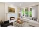 Comfortable living room featuring fireplace, hardwood floors, and natural light streaming through large windows at 1740 Doncaster Ne Dr, Atlanta, GA 30309