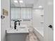 This bathroom features dual sinks, a large mirror, and a tub with white tiles at 339 Diane Se Dr, Smyrna, GA 30082