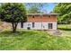 Brick and cinderblock home exterior with a backyard fire pit and outdoor deck surrounded by lush greenery at 339 Diane Se Dr, Smyrna, GA 30082