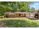 Traditional brick home with a green lawn, mature trees, and a convenient carport at 339 Diane Se Dr, Smyrna, GA 30082