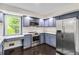 This kitchen features blue cabinets, stainless steel appliances, and a window with a view at 339 Diane Se Dr, Smyrna, GA 30082