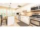Well-lit kitchen featuring stainless steel appliances, white cabinetry, granite counters, and a cozy breakfast bar at 3910 Ashford Lake Ne Ct, Brookhaven, GA 30319