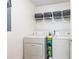 Functional laundry room with washer, dryer, shelving, and storage baskets for organization and convenience at 3910 Ashford Lake Ne Ct, Brookhaven, GA 30319