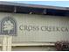 Close up on the Cross Creek Cafe sign with the tree logo and modern sans serif lettering at 143 Lablanc Nw Way, Atlanta, GA 30327