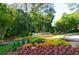 Landscaped entrance to Cross Creek community with stone sign and colorful flowers at 143 Lablanc Nw Way, Atlanta, GA 30327