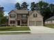 Charming two-story home with a well-manicured lawn, brick facade, and a two-car garage at 3531 Lilly Brook Dr, Loganville, GA 30052