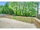 A stone patio with a wooden fence surround leads to a grassy backyard with mature trees at 3550 Willow Tree Trce, Decatur, GA 30034
