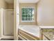 Bathroom with a separate shower and a large soaking tub by a window at 3550 Willow Tree Trce, Decatur, GA 30034