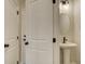 Stylish powder room boasts a pedestal sink, oval mirror, and sleek fixtures at 4517 Twinberry Dr, Powder Springs, GA 30127