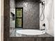 Close up of a contemporary bathroom showcasing a luxurious soaking tub and modern fixtures at 5020 Vallo Vista Ct, Atlanta, GA 30342