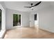 Bedroom with hardwood floors, a modern ceiling fan, and a large window with treed view at 5020 Vallo Vista Ct, Atlanta, GA 30342