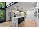 Modern kitchen featuring an island with marble countertop, stainless steel appliances, and views from the large windows at 5020 Vallo Vista Ct, Atlanta, GA 30342
