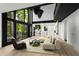 Bright living room featuring a modern sofa, accent chair, and large windows offering scenic views of surrounding trees at 5020 Vallo Vista Ct, Atlanta, GA 30342