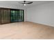 Living room with wood floors, fan, and sliding glass doors to an outdoor screened in deck at 5020 Vallo Vista Ct, Atlanta, GA 30342