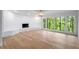 Bright living room featuring a stone fireplace, large windows with a view, and sleek flooring at 5020 Vallo Vista Ct, Atlanta, GA 30342