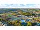 Community aerial view highlighting a pool, tennis courts, clubhouse, and surrounding scenic landscape at 553 Princeton Elm Place Way, Lawrenceville, GA 30045