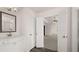 Bathroom with double doors to main bedroom, white cabinets, granite countertop, and walk-in shower at 553 Princeton Elm Place Way, Lawrenceville, GA 30045