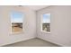 Bedroom with neutral walls, carpet, and two windows overlooking the neighborhood at 553 Princeton Elm Place Way, Lawrenceville, GA 30045