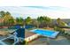 Aerial view of a community pool, tennis courts, and clubhouse in a wooded setting at 553 Princeton Elm Place Way, Lawrenceville, GA 30045