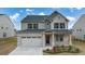 Charming two-story home featuring a brick and siding exterior, covered porch, and two-car garage at 553 Princeton Elm Place Way, Lawrenceville, GA 30045