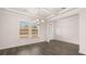 Bright, open living room featuring hardwood floors and a modern chandelier, and an abundance of natural light at 553 Princeton Elm Place Way, Lawrenceville, GA 30045