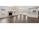 Open living area with a stone fireplace, hardwood flooring, and a view of the modern kitchen at 553 Princeton Elm Place Way, Lawrenceville, GA 30045