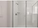 Modern bathroom shower featuring white subway tiles and glass doors at 553 Princeton Elm Place Way, Lawrenceville, GA 30045