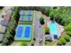 Aerial view of community tennis courts and pool, surrounded by lush greenery and neighborhood homes at 6468 Pierless Ave, Sugar Hill, GA 30518