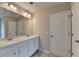 Bathroom with double sink vanity, large mirror, and multiple white doors at 6468 Pierless Ave, Sugar Hill, GA 30518