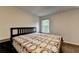 Bedroom with wood floors, a black headboard and a patterned blanket. A window provides natural light at 6468 Pierless Ave, Sugar Hill, GA 30518