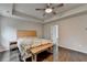 Bedroom with tray ceiling, ceiling fan, wood floors, and a wooden bench at the foot of the bed at 6468 Pierless Ave, Sugar Hill, GA 30518