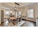 Bright dining area with wood floors, modern lighting, and seating for six in view of the screened in porch at 6468 Pierless Ave, Sugar Hill, GA 30518