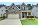 Charming two-story home with a stone and brick facade, two-car garage, and well-maintained landscaping at 6468 Pierless Ave, Sugar Hill, GA 30518