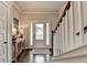 Bright foyer features hardwood floors, a console table, and a staircase leading to the upper level at 6468 Pierless Ave, Sugar Hill, GA 30518