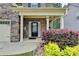 Inviting front porch with stone accents, colorful flower beds, and a charming entrance at 6468 Pierless Ave, Sugar Hill, GA 30518
