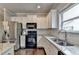 Modern kitchen with white cabinets, granite counters, stainless appliances, and double sink at 6468 Pierless Ave, Sugar Hill, GA 30518