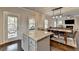 Open kitchen with island seating, leading into the dining area and a living room with fireplace at 6468 Pierless Ave, Sugar Hill, GA 30518